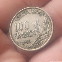 Obverse side of 1955 100 Francs coin showing denomination, year, and agricultural motifs.