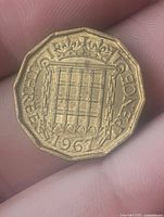 Reverse of 1967 England three pence coin featuring detailed iron gate design, year 1967, and denomination 'THREE PENCE'.