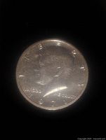 Close-up photo of the 1971 JFK half dollar coin, showing obverse with Kennedy profile, date 1971, and inscriptions.