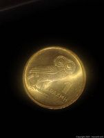 Obverse side of the coin showing owl and Greek inscription.