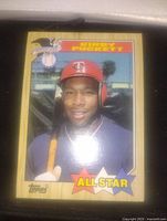 Front photo of Kirby Puckett 1987 Topps All-Star baseball card showing the player with bats and All-Star label at bottom in colored stars.