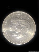 Front of 1981 England large commemorative coin showing Prince Charles and Diana Spencer profile heads and date.