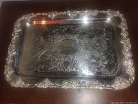 Overall top view of silver plated rectangular serving tray showing ornate grapevine detailed border and scrollwork pattern on flat surface