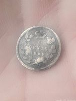 Reverse side of 1899 Canadian 5 cent coin with denomination, crown, wreath and year 1899.