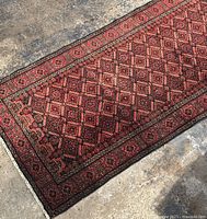 Angled view showing geometric diamond pattern across length of rug