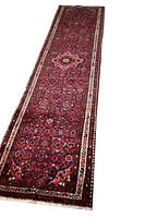 Full-length view of the red runner rug showing central medallion and border pattern