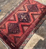 Full top view of rust-red field and navy medallions on concrete floor