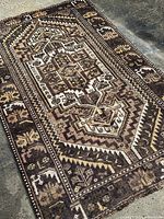 Photo of a geometric design Shiraz tribal rug laid flat showing the border and central medallion pattern.