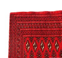 Close-up photo showing the detailed geometric and tribal patterns, with dominant red, black and beige colors.