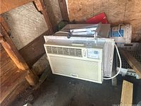 Whirlpool air conditioner unit in beige/white color with vent and controls, showing overall front and side view.