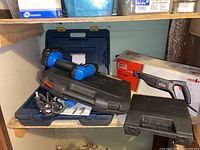 Photo of Mastercraft drills and drill kit in black and blue, including hammer drill case and attached cord of electric drill.