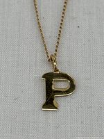 Close-up of letter P pendant showing shape and finish