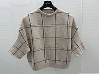 Full front view of light gray cashmere sweater on hanger