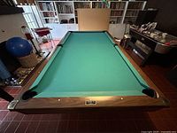 Full view of table from foot end showing green felt and walnut finish.