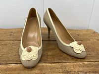 Front three-quarter view of pair showing linen upper, cream trim and floral appliqué