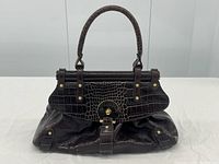 Full front view of handbag showing silhouette, flap and handle