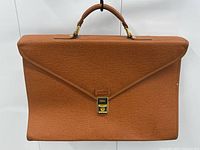 Front view of tan leather briefcase closed