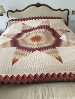 Full view of quilt on bed showing central star, border and overall condition