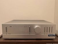 Front view of silver faceplate showing power switch, volume knob, input selector levers, Super-A badge