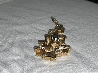 Angled front view showing geometric block design and central sapphire