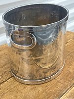 Front side view showing integrated oval handle and polished silver-plated finish.