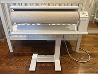 Front view of entire mangle on stand showing roller and base