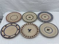 Overview of all six plates arranged in two rows on a white fabric background