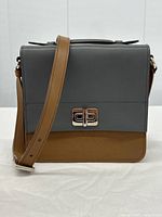 Front view showing grey flap, tan base, and silver-tone turnlock closure