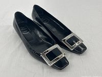 Pair of flats angled to show buckle detail and square toe shape