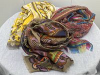Group shot of three folded scarves showing all colorways and patterns