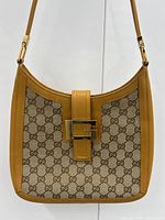 Front view showing GG canvas panels, leather trim and gold G buckle