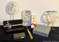 Overview of Asian gift sets including silk fans, pillboxes in fabric-covered box, chopsticks set and smaller boxes