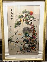 Full view of the embroidered silk artwork framed under glass, showing many birds around a tree with a red sun in the background.