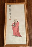 Overall view of framed silk embroidery showing full figure and wooden frame