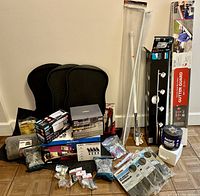 Full view of lot contents including floodlight cams, gutter guards, mats, curtain rods and tools