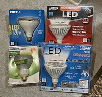 Four LED light bulbs in original packaging, mostly large reflector or flood light type, from Cree, Feit Electric, and Philips
