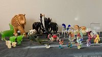 Overview showing assorted collectible animal figurines including hand-blown glass animals, wooden and jadeite animals.