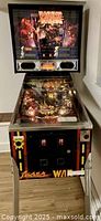 Full front view of pinball machine showing cabinet, legs and backbox