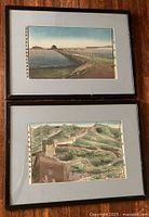 Photo showing both framed silk kesi tapestries together on a wooden wall: coastal scene on top, Great Wall below
