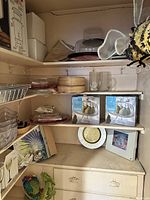 Shelves showing assorted items including boxed cake plates, glassware, boxes of coffee urns, and other kitchen/party related items.