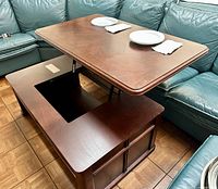 View showing the lift-top partially raised and the empty rectangular center of the table base.