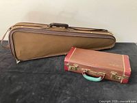 Two instrument cases for violin and clarinet, brown cloth case for violin and smaller red and brown vintage case for clarinet