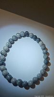 Photo of stretchy natural map jasper bracelet with round polished beads in gray and white tones.