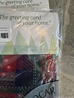 Packaged holiday flag with red and green plaid pattern visible through plastic, showing size 12.5 x 18 inches on packaging