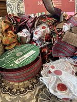 Photo showing assorted Christmas ribbons and bows in various patterns and colors, including plaid and glittery white with red accents.