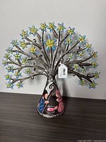 Metal nativity artwork showing figurines of Mary, Joseph, and baby Jesus with star decorations