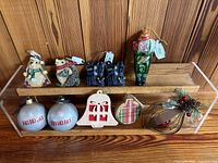 Full set of 10 Christmas ornaments displayed on wooden shelves including figurines, wooden shapes, glass balls, and fabric/resin decorated items.