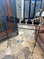 Front view of the black metal fireplace screen showing full train silhouette design, positioned indoors on tiled floor.