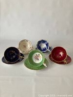 Front view of five assorted Coalport bone china teacups and saucers arranged side by side showing variety of colors and patterns.