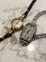 Overview of both watches on marble surface